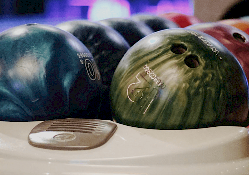 Bunte Bowlingkugeln in Ballrücklauf.